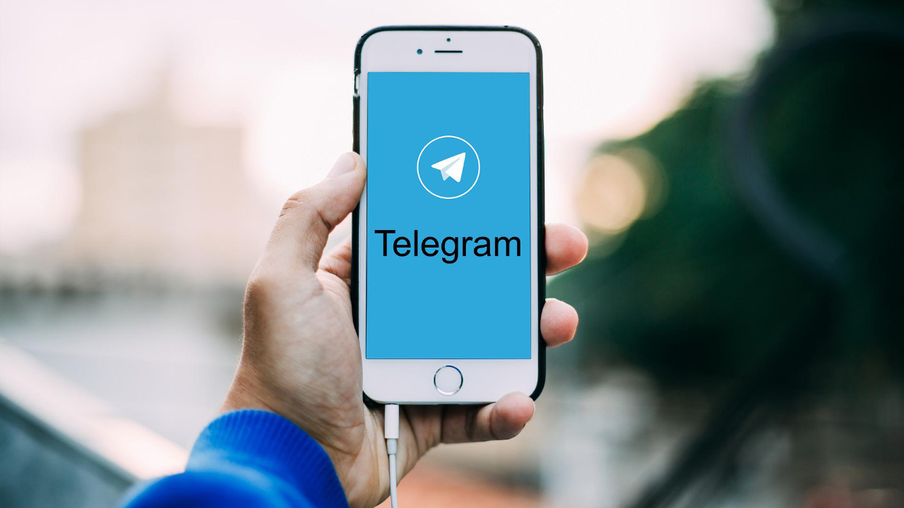 A person holding a mobile phone with Telegram Messenger Tricks