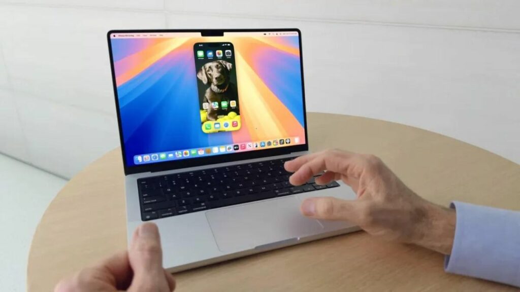 macOS Sequoia - a man on his MacBook using iPhone Mirroring feature