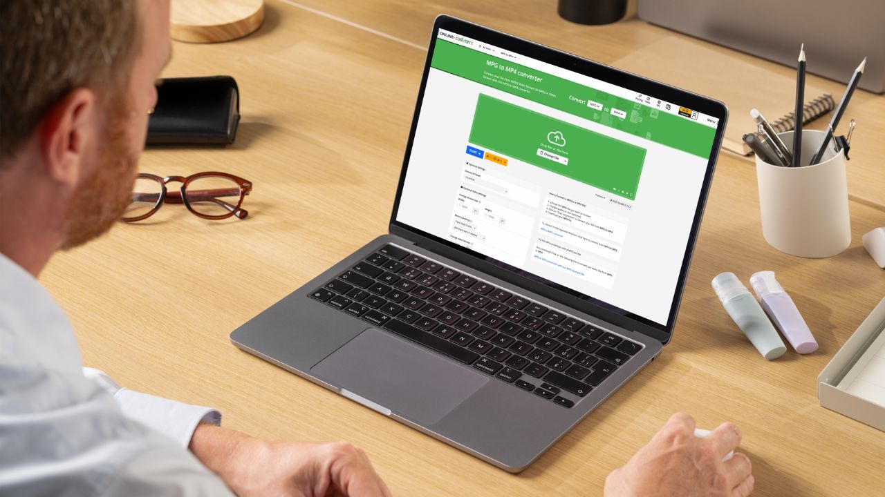 A man converting MPG files to MP4 on his laptop using Online Convert.